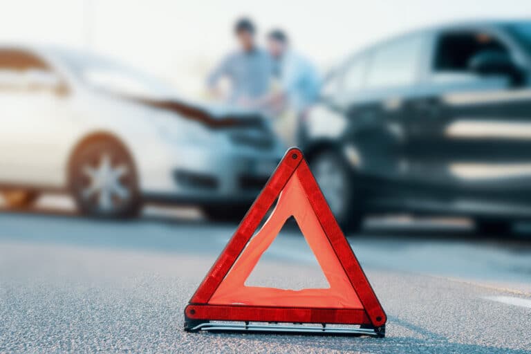 Two men reporting a car crash for an insurance claim.